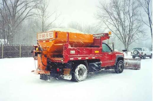 Snow Plow Machine Removing Snow from City Pavement