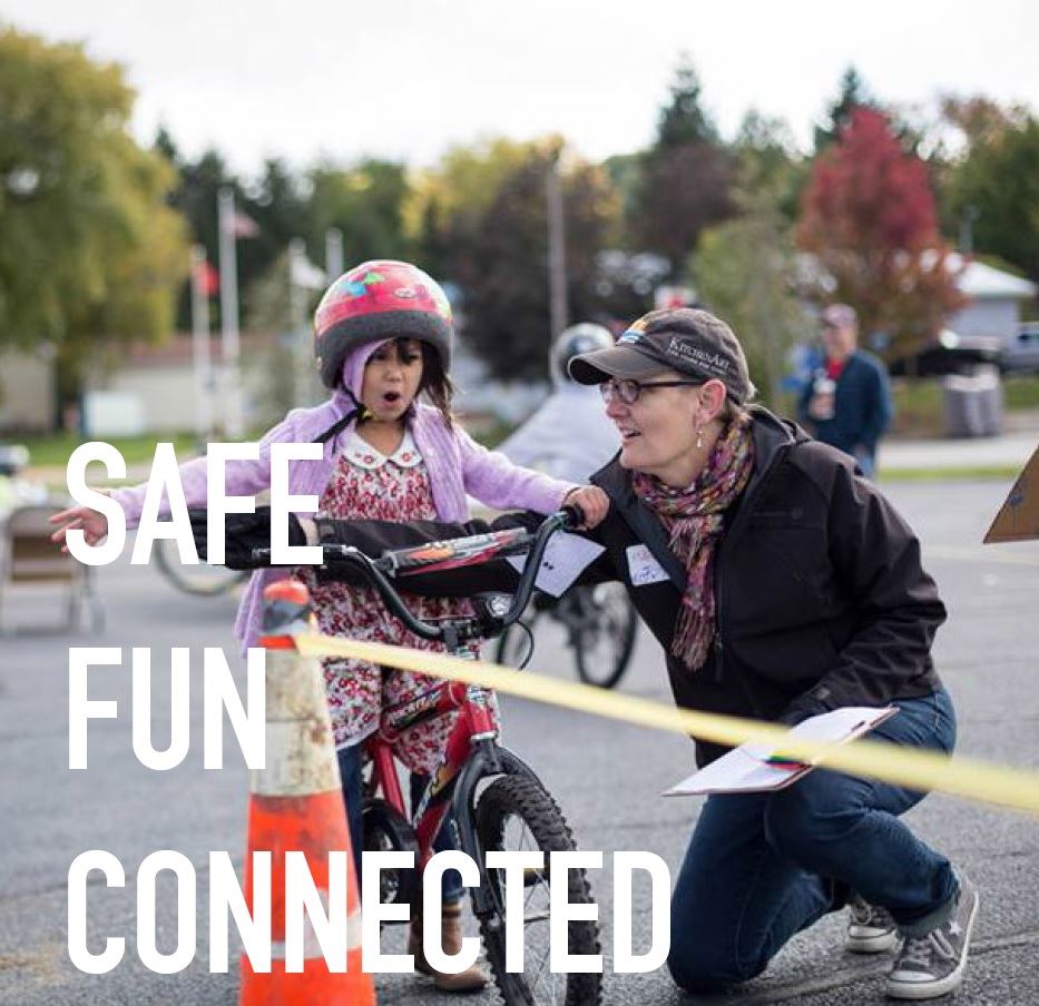 woman helping girl on bicycle
